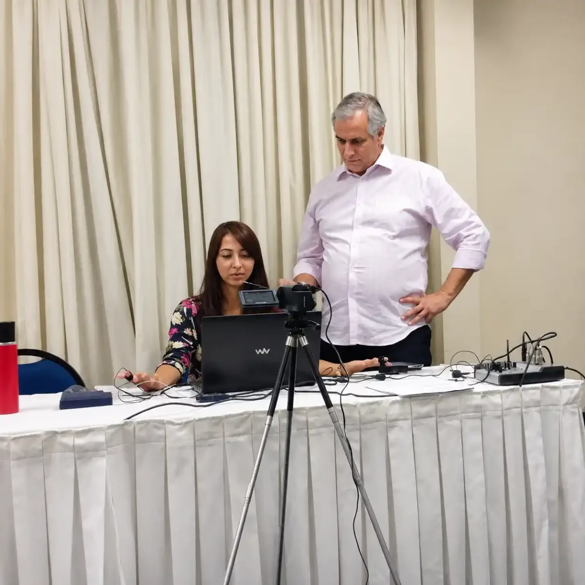 Equipe prepara câmera, computador e equipamentos durante atividade do IBRALC sobre comportamento humano.